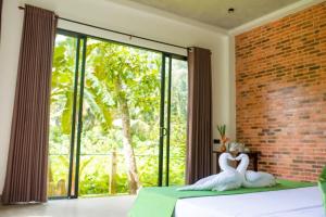 two white swans sitting on a bed in a bedroom at Blue Horizon By Capt Logus in Ja-Ela