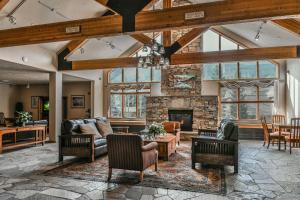 an open living room with a stone fireplace at Gateway Lodge 5099 by SummitCove Lodging in Colorado in Keystone