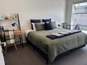 a bedroom with a bed with two remote controls on it at Mermaid Waterways in Whitianga