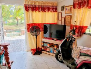 a living room with a television and a scooter in a room at Cabaña Villa Gabi in San Antero