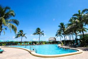 a swimming pool with palm trees in a resort at Amazing beachfront condo at Tides on Hollywood Beach Luxury Resort in Hollywood