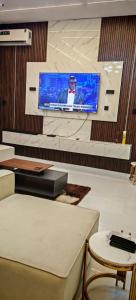 a tv on a wall in a room with a table at Prince-Coll apartment in Lagos +12 photos