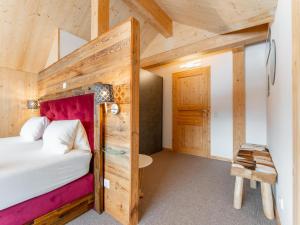 a bedroom with a bed and a wooden wall at Lachende Eule in Hohentauern