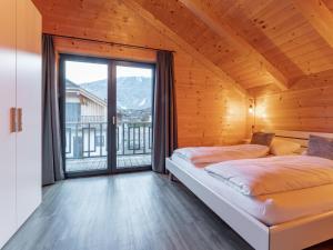 two beds in a room with a large window at Rattendorf 11B in Rattendorf