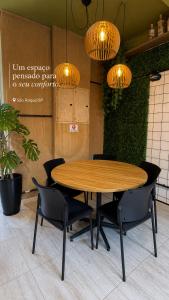 a wooden table and chairs in a room with lights at São Hostel in São Roque +11 photos