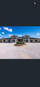a large white building with a yard in front of it at Mudgee Gardens Stayz in Mudgee