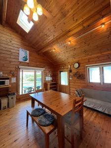 a wooden dining room with a table and a couch at Family Cottage Pokhara in Yamanakako +9 photos