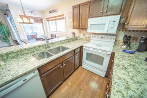 a kitchen with white appliances and wooden cabinets at Flying Dutchman 1115 by SummitCove Lodging in Colorado in Keystone