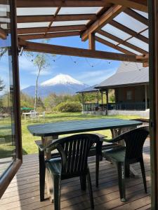 a table and chairs on a deck with a snow covered mountain at Family Cottage Pokhara in Yamanakako