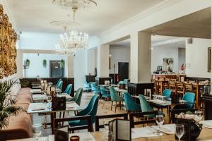 a restaurant with tables and chairs and a chandelier at The Kings Arms Hotel in Berwick-Upon-Tweed