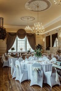 a banquet room with white tables and chairs and a chandelier at The Kings Arms Hotel in Berwick-Upon-Tweed