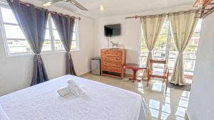 a bedroom with a bed and a dresser and windows at Casa ka'an in Isla Mujeres