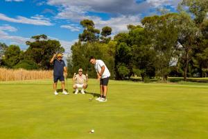 three men playing golf on a golf course at Robinvale Golf Club Resort in Robinvale 