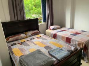 a bedroom with two beds and a window at Hostal Belletini in Manta