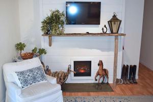 a living room with a fireplace and a tv at The Tack Room in Naples