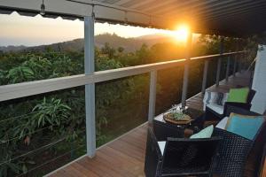 a balcony with chairs and a table and the sunset at The Tack Room in Naples