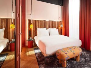 a bedroom with a large white bed and a stool at Mama Shelter Rennes in Rennes +227 photos