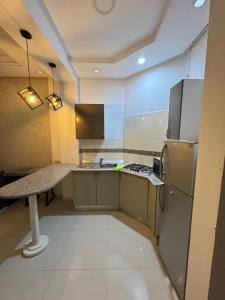 a kitchen with a refrigerator and a counter top at Apt A3 in Siliana