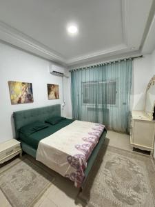 a bedroom with a green bed and a window at Apt A3 in Siliana