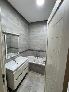 a bathroom with a sink and a bath tub at Apt A3 in Siliana
