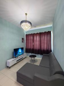 a living room with a couch and a tv at Aileen Homestay in Tawau