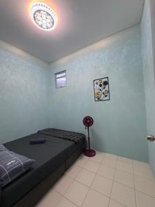 a bedroom with a bed and a light on the ceiling at Aileen Homestay in Tawau +3 photos