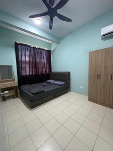 a bedroom with a bed and a ceiling fan at Aileen Homestay in Tawau
