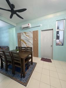a dining room with a table and chairs and a ceiling fan at Aileen Homestay in Tawau