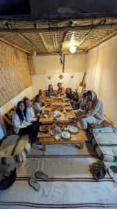 a group of people sitting around a wooden table at Emallayan Hostel in Imsouane +50 photos