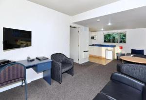 a living room with a desk and chairs and a table at Anika Motel in Christchurch