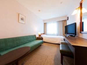 a hotel room with a couch and a bed at Grand Plaza Nakatsu Hotel in Nakatsu +15 photos