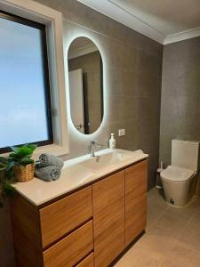 a bathroom with a sink and a mirror and a toilet at Cygnet Escape in Cygnet River +3 photos