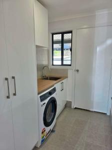 a kitchen with a washing machine and a sink at Cygnet Escape in Cygnet River