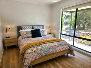 a bedroom with a bed and a large window at Cygnet Escape in Cygnet River