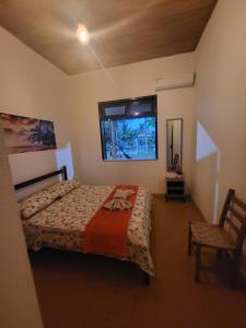 a bedroom with a bed and a window and a chair at Chácara Amsterdam in Aracaju +26 photos