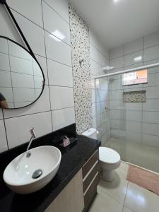 a bathroom with a sink and a toilet and a mirror at Casa elegante, próximo às cataratas in Foz do Iguaçu +48 photos