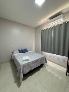a bedroom with a bed with two towels on it at Casa elegante, próximo às cataratas in Foz do Iguaçu