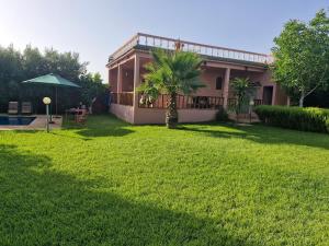 a house with a green yard with a patio at Casa Sofia in Meknès