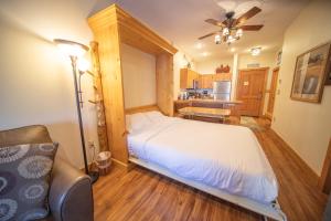 a bedroom with a large bed and a kitchen at Expedition Station 8554 by SummitCove Lodging in Colorado in Keystone