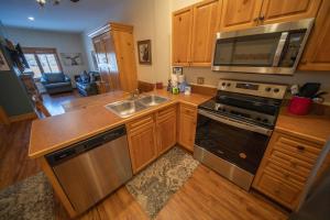 a kitchen with wooden cabinets and stainless steel appliances at Expedition Station 8554 by SummitCove Lodging in Colorado in Keystone