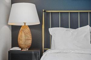 a lamp on a night stand next to a bed at Kasa LoHi Denver in Denver