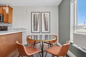 a dining room with a glass table and chairs at Kasa LoHi Denver in Denver