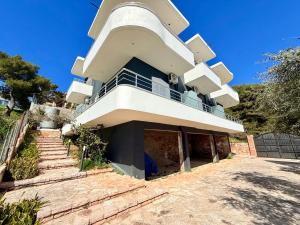 a building with a balcony on top of it at Davide Rooms in Sarandë