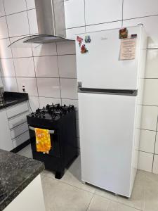 a white refrigerator in a kitchen with a stove at Casa elegante, próximo às cataratas in Foz do Iguaçu