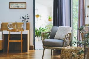 a living room with a chair and a table at Cloudy Homestay Hoi An in Hoi An