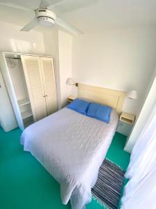 a bedroom with a white bed with blue pillows at Diva gues del Pereyra Sur in Villa Elisa +34 photos