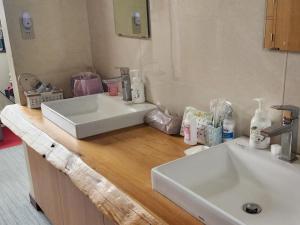 a bathroom with two sinks on a wooden counter at 湯畑源泉宮崎館 in Kusatsu