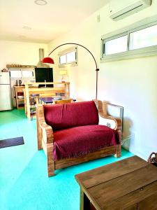 a living room with a red couch and a table at Diva gues del Pereyra Sur in Villa Elisa