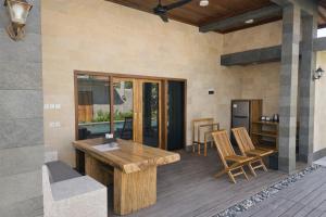a patio with a wooden table and chairs at Taman Senang - Private Pool Villas - Gili Air in Gili Islands
