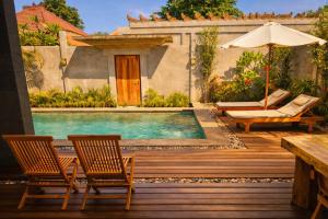 a pool with chairs and an umbrella on a wooden deck at Taman Senang - Private Pool Villas - Gili Air in Gili Islands